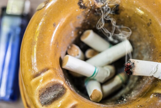 Cigarette on ashtray with smoke