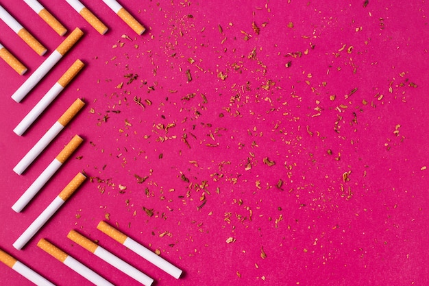 Cornice di sigarette su sfondo rosa