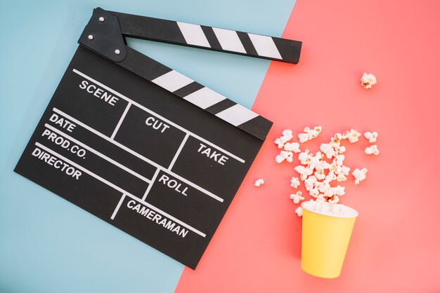 Cinema clapperboard with popcorn box