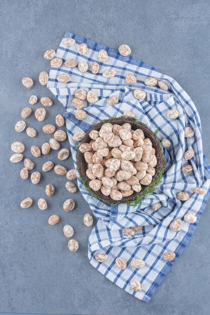 Cinnamon candies in the bowl, on the towel on the marble background. 