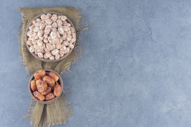 Cinnamon candies and date fruits , on the marble background. 