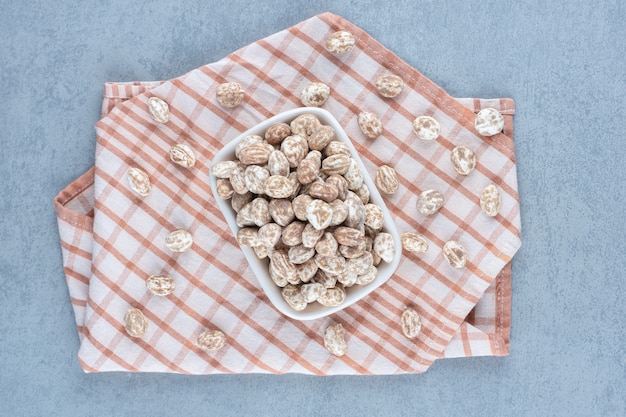 Foto gratuita confetteria alla cannella nella ciotola sull'asciugamano, sul tavolo di marmo.