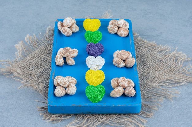 Cinnamon confectionery with biscuit on the board, on the trivet, on the marble table. 