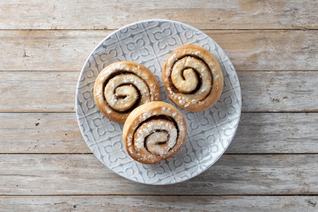 Foto gratuita panini alla cannella su un tavolo di legno con spazio per la copia dessert svedese kanelbulle