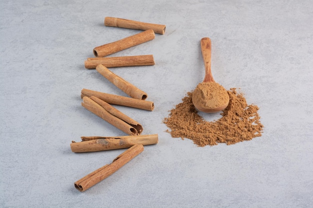 Free photo cinnamon sticks and blended powder in a wooden spoon.