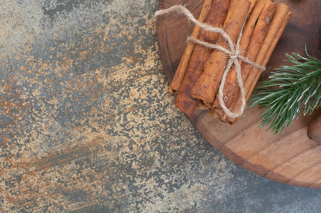 Free photo cinnamon sticks in rope on marble background. high quality photo