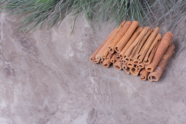 Free photo cinnamon sticks in a row on the stone surface