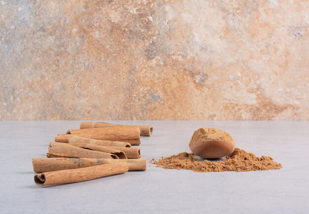 Cinnamon sticks with powder on concrete background. 