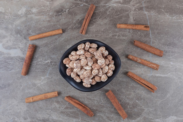 Cinnamons and confectionery on the trivet on the marble surface