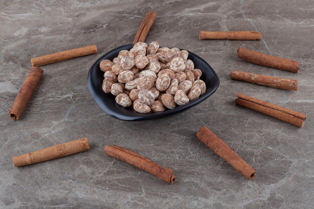 Cinnamons and confectionery on the trivet on the marble surface