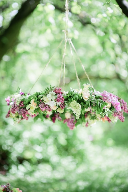 Circle made of violet and white lilac hangs from the tree