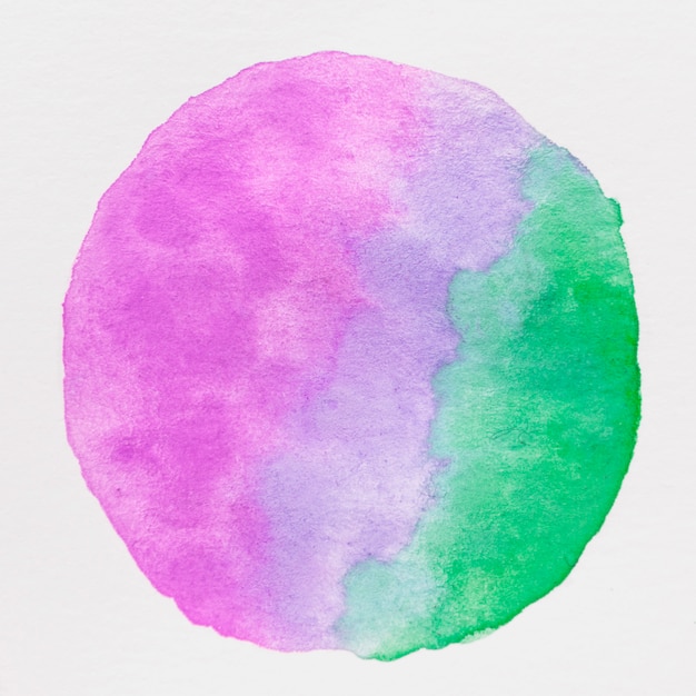 Circle made with purple and green water color paint on white background