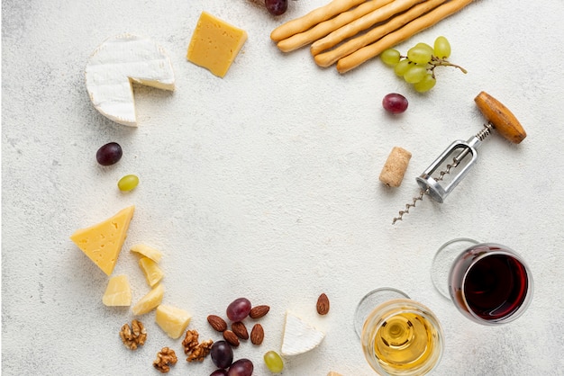 Free photo circle shape formed of wine and cheese on table