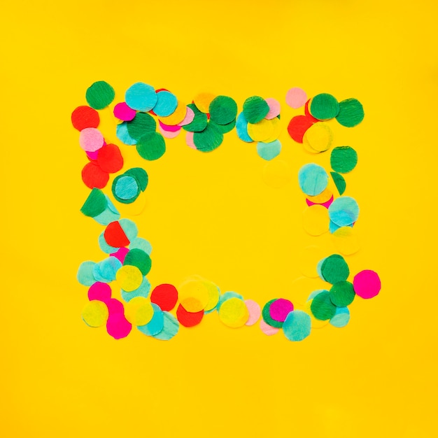 Circular confetti frame border on yellow background