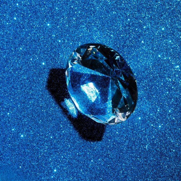 Круглый бриллиант на фоне блестящей синей текстуры