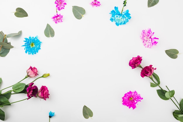 Бесплатное фото Круглая рамка с цветами на белом фоне