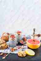 Free photo citrus fruit slices; healthy smoothie with backed cookies and croissant on napkin