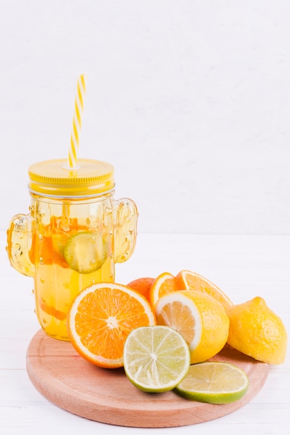 Free photo citrus fruits and juice on wooden board