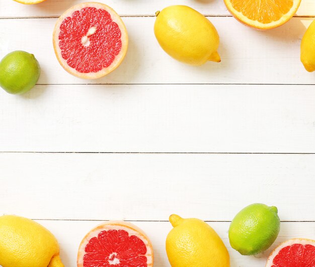 Citrus fruits on wooden table, top view, copyspace background