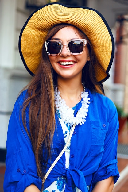 Free photo city lifestyle fashion portrait of happy pretty girl walking alone having fun on the street, evening sunlight, retro dress vintage hat, happy positive mood.