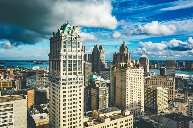 Городской пейзаж Детройта под солнечным светом и темным облачным небом в дневное время