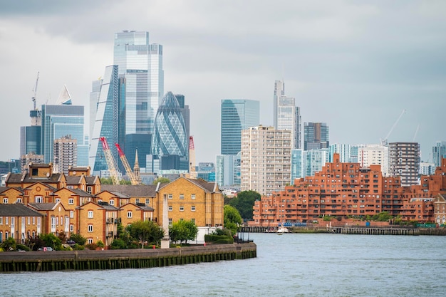 Foto gratuita paesaggio urbano del fiume tamigi di londra, regno unito, con edifici residenziali sui lati del quartiere finanziario con grattacieli in lontananza