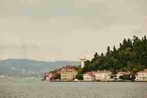 Free photo the cityscape with ancient and modern buildings in istanbul turkey from the bosphorus strait on a sunny day with background cloudy sky