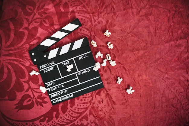 Clapper board and popcorn on velvet cloth