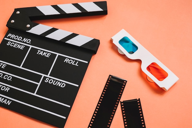 Clapperboard next to 3d glasses and film reels