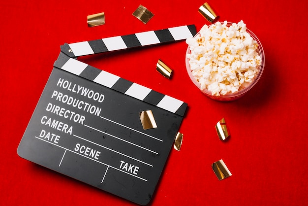 Clapperboard near small bowl of popcorn