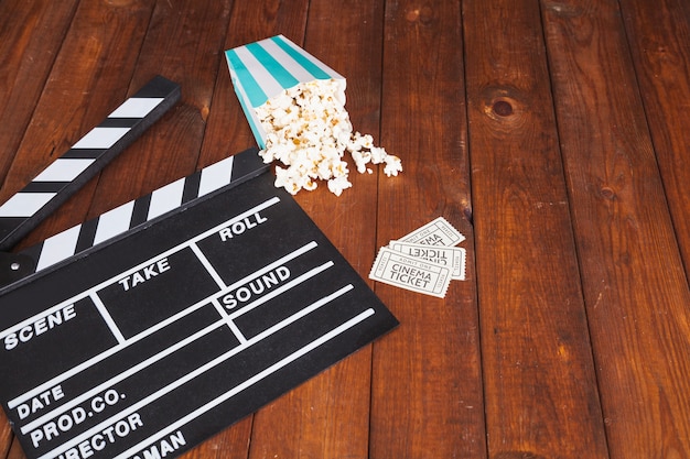 Clapperboard and popcorn with tickets