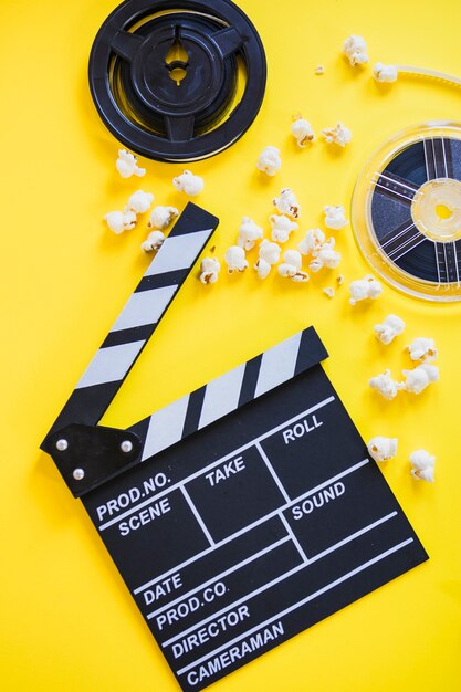 Clapperboard with popcorn and reels