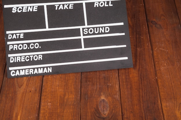 Free photo clapperboard on wooden tabletop