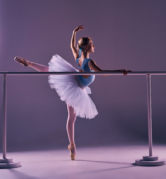 Classic ballerina posing at ballet barre