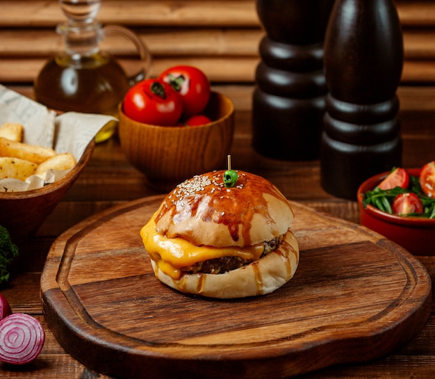 Classic cheeseburger on wooden board