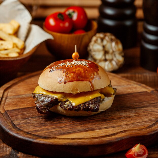 Classic cheeseburger on wooden board