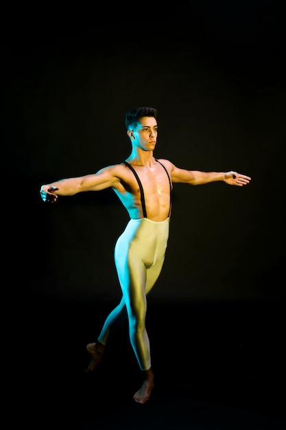 Classic male ballet dancer performing in spotlight