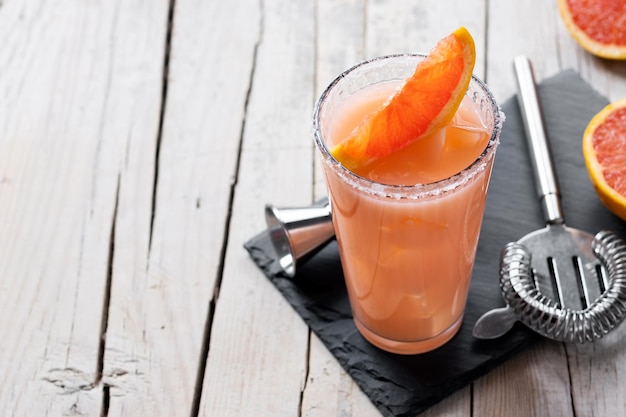 Classic paloma cocktail on wooden table. Copy space