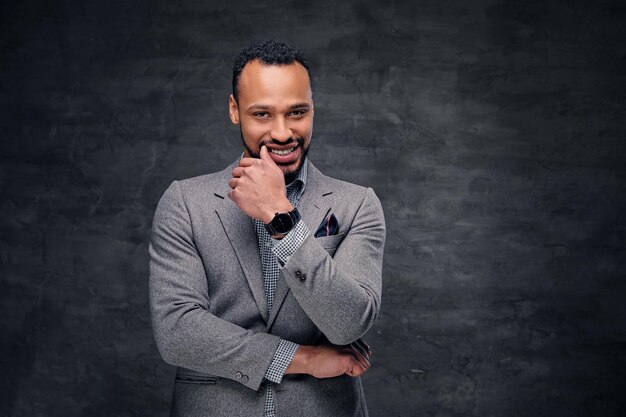 Classic studio portrait of black American male dressed in a suit over grey vignette background.