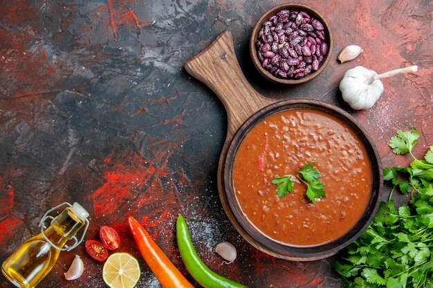 Classic tomato soup fallen oil bottle beans on cutting board on a mixed color table