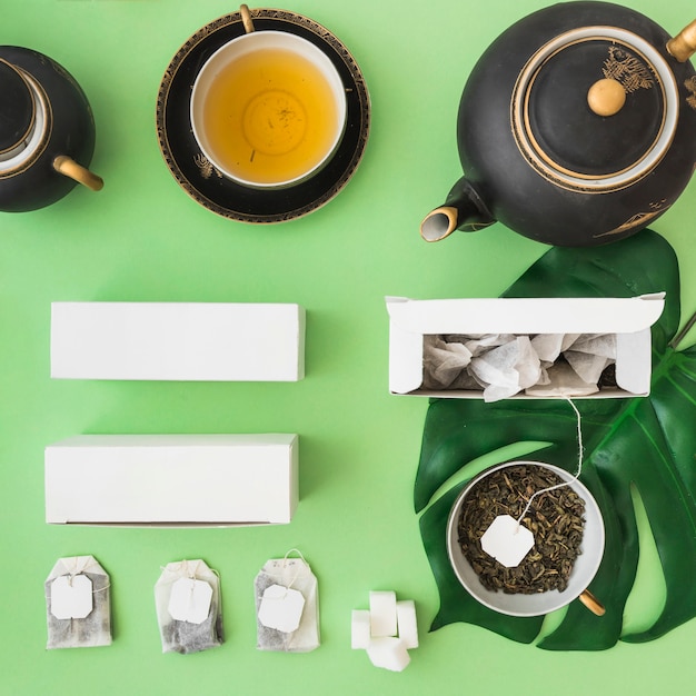 Classical asian tea set with herbal tea bag on green background