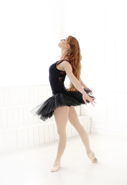 Классическая балерина в черном платье тренируется для черного лебедя