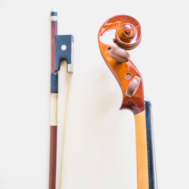 Классическая музыкальная скрипка и лук на белом фоне