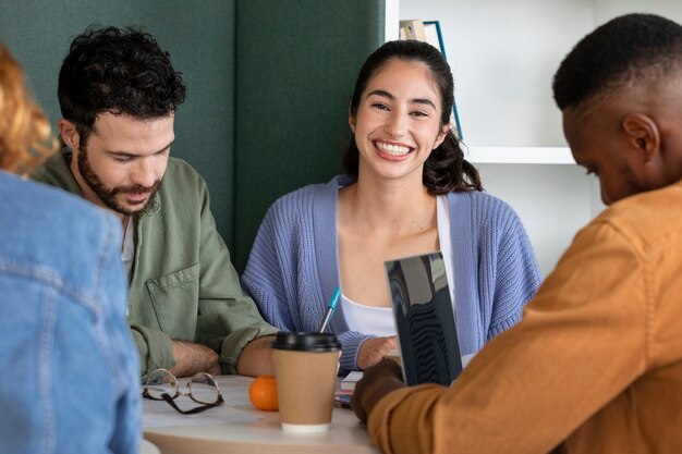 Foto gratuita compagni di classe che leggono e imparano da appunti e laptop