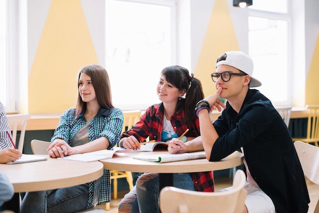 Free photo classmates sitting and learning at desk