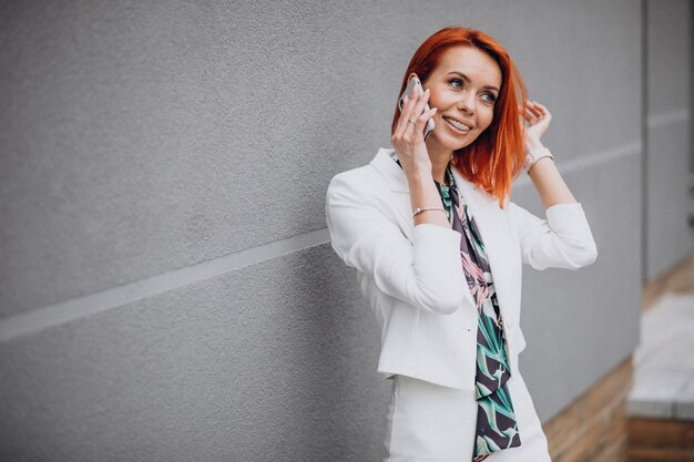 Classy business woman in white suit talking on the phone