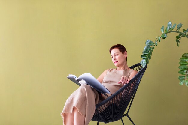 Free Photo Adult Woman Sitting In Chair Drinking Coffee And Reading