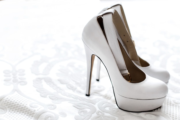 Classy white platform shoes stand on white embroidered cloth