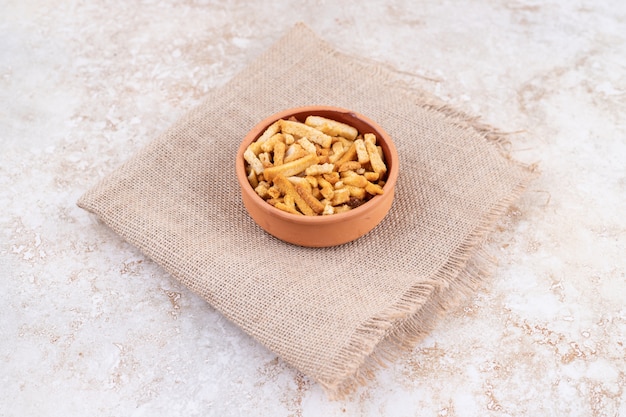 Free photo a clay bowl of breadsticks on a sackcloth