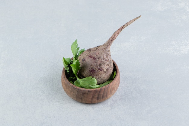 A clay bowl radish with parsley , on the marble.